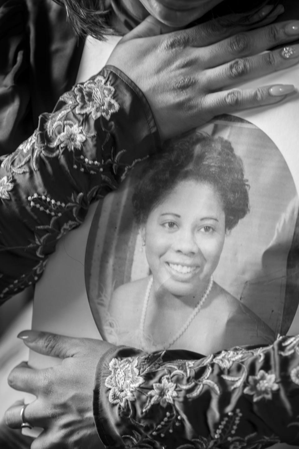 A lady holding a photo of a woman.