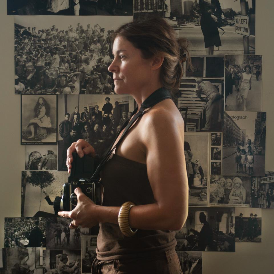 The profile of a woman and her camera taken from the side. 