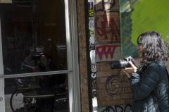 A lady holding a camera outside.