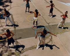 Kids outside playing with a hula hoop.