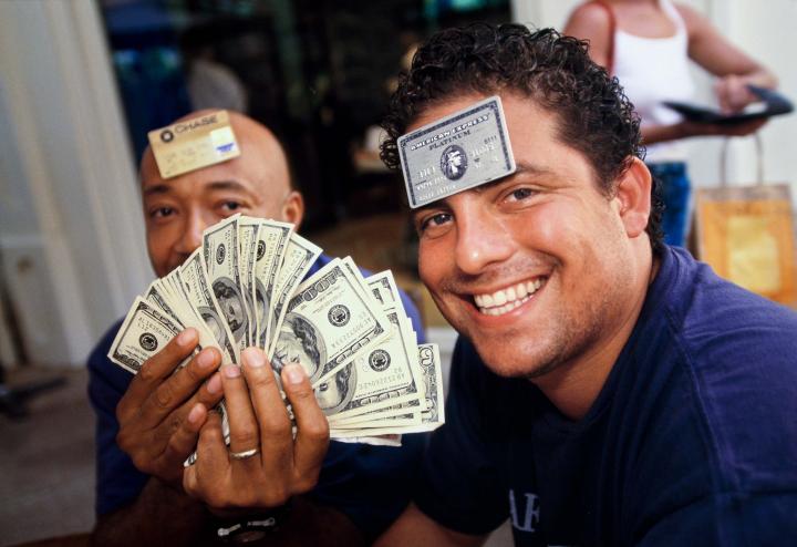 Two guys with money and credit cards showing.
