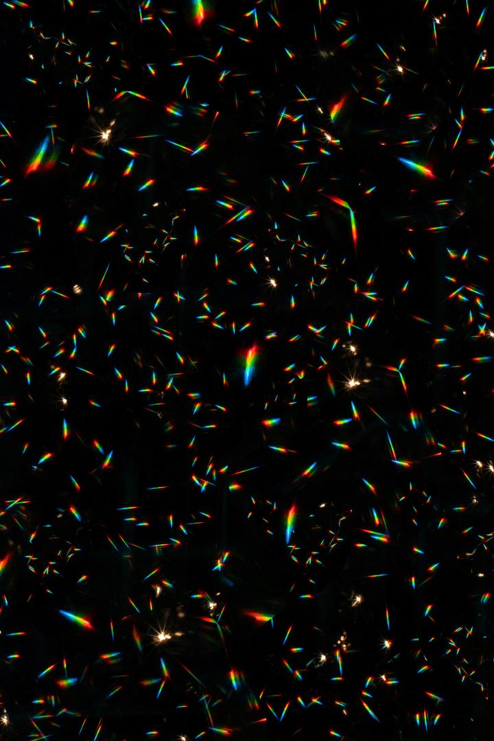 A display of rainbow light reflections with an otherwise pitch black background.  