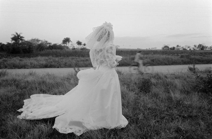 A person wearing a white dress outside.
