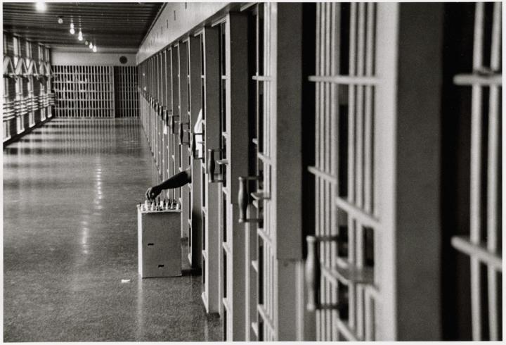 A man playing chess in jail.