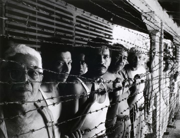 A group of people behind barbed wire.