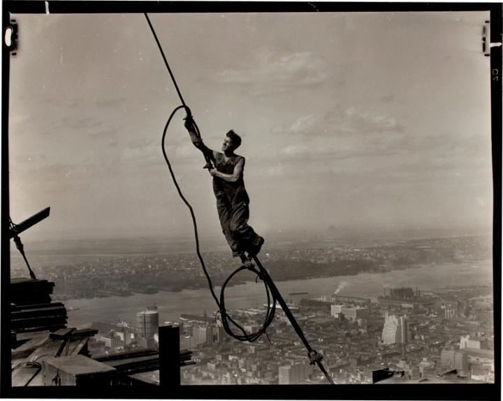 A construction worker dancing off of a cable high above NYC. 