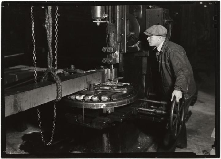 A factory worker and his machine. 