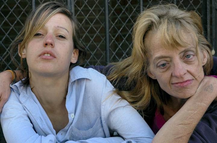 A two women, one neurotypical and one with a mental disorder sit down in front of the camera. 