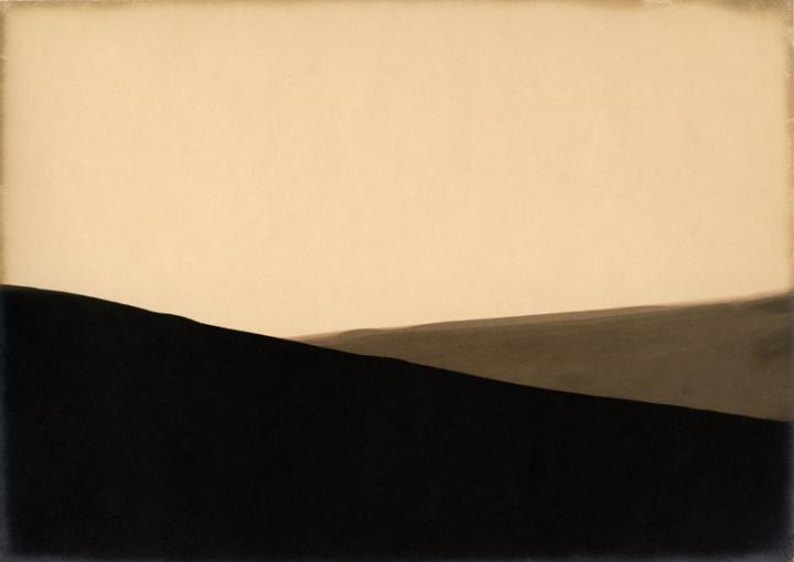 An abstract shade of black and another shade of grey overlapping, the background is a faded yellow.